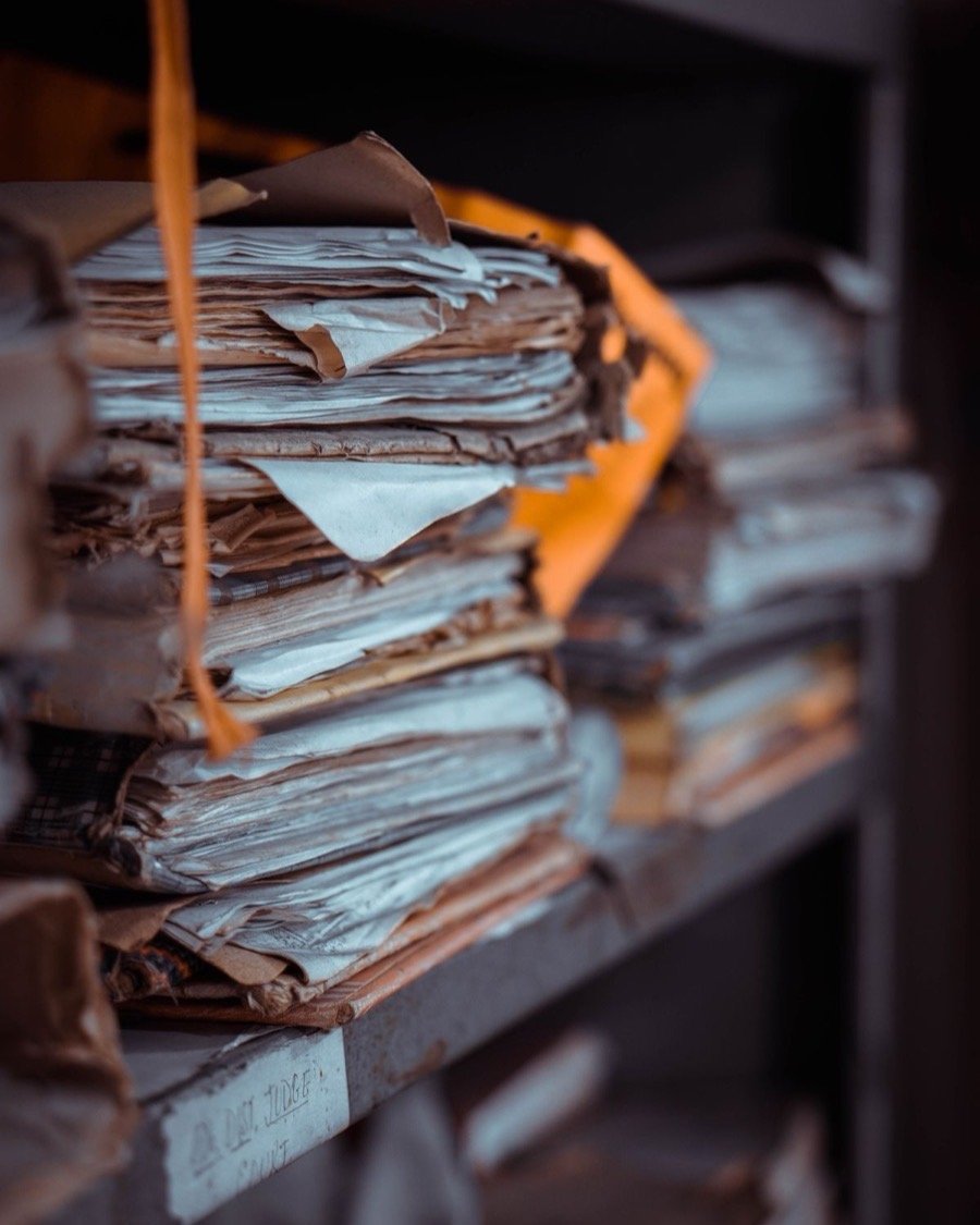 Des piles de dossiers archivés sur une étagère